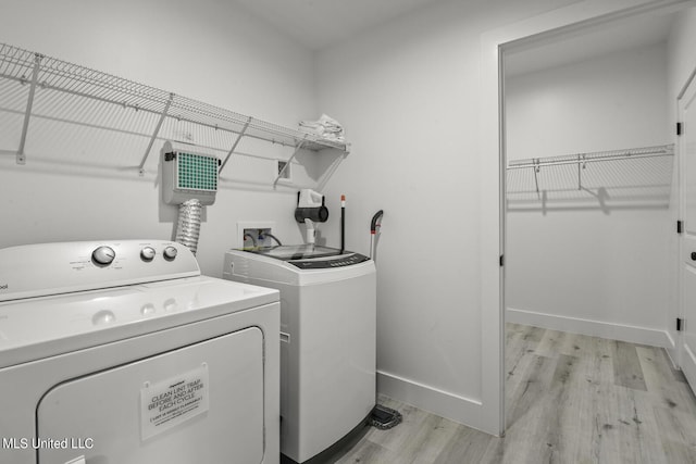 1302 Magnolia St Unit 109, Gulfport, MS 39501 - clothes washing area with baseboards, laundry area, light wood-type flooring, and washer and clothes dryer