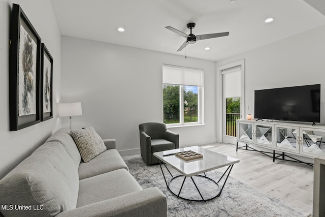 living room featuring ceiling fan and light hardwood / wood-style flooring