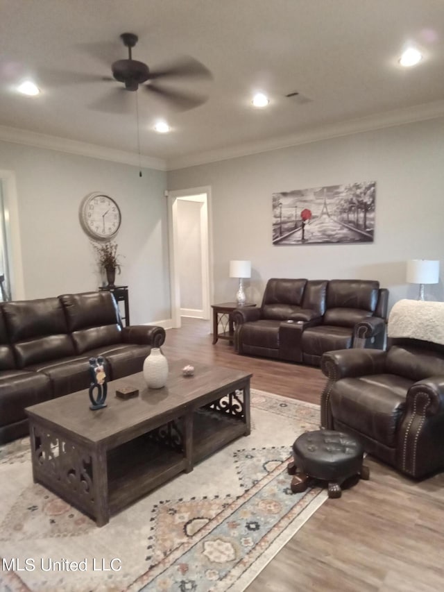 living room featuring ornamental molding, light wood-type flooring, and ceiling fan