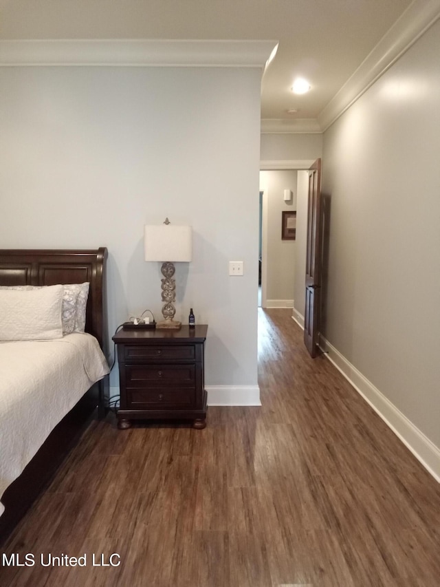 bedroom featuring crown molding and dark wood-type flooring