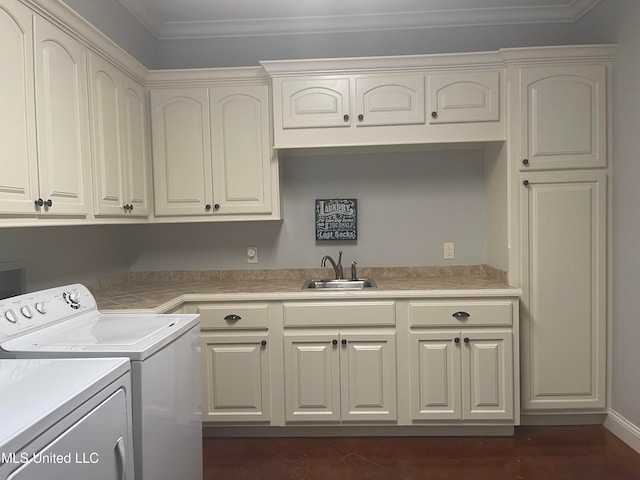 washroom with ornamental molding, sink, cabinets, washing machine and dryer, and dark hardwood / wood-style flooring