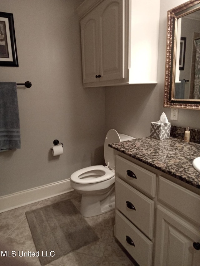 bathroom featuring toilet, vanity, and tile patterned floors