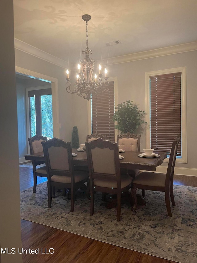 dining space featuring crown molding, dark hardwood / wood-style floors, and a notable chandelier