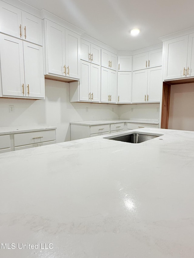 kitchen with white cabinets and light stone countertops