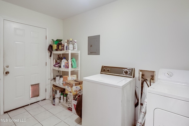 laundry room with light tile patterned floors, electric panel, and washing machine and clothes dryer