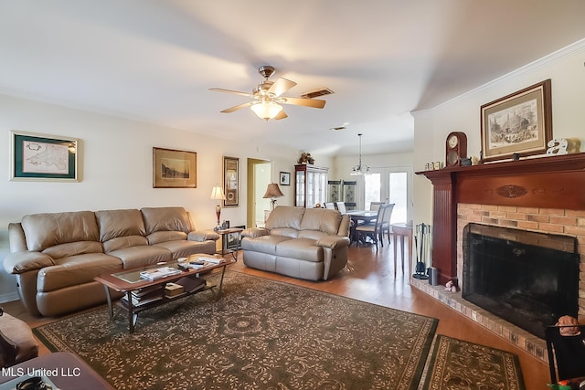 living room featuring a brick fireplace, wood-type flooring, and ceiling fan