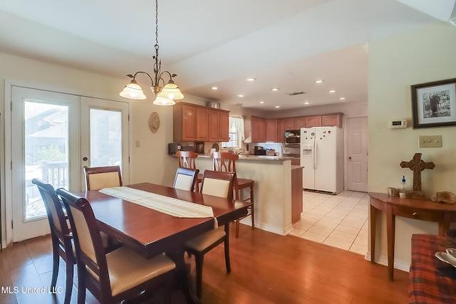 dining space with a wealth of natural light, light hardwood / wood-style floors, and french doors