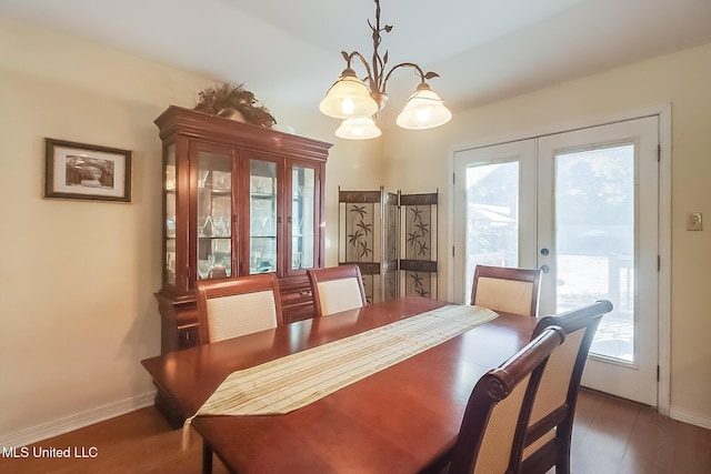 dining room with a healthy amount of sunlight, an inviting chandelier, dark hardwood / wood-style flooring, and french doors