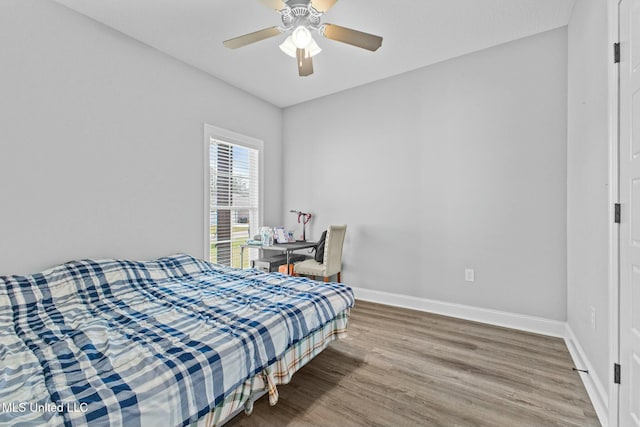 bedroom with ceiling fan, baseboards, and wood finished floors