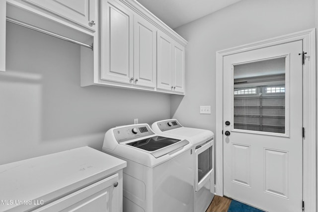 clothes washing area featuring cabinet space, separate washer and dryer, and dark wood-type flooring