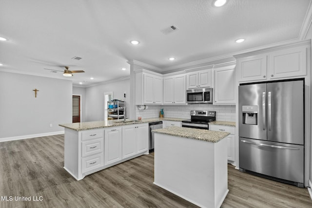 kitchen featuring visible vents, backsplash, ornamental molding, appliances with stainless steel finishes, and a peninsula