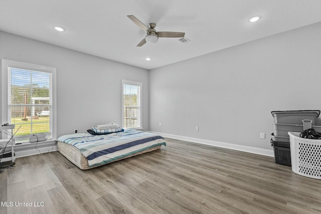 bedroom with recessed lighting, visible vents, baseboards, and wood finished floors