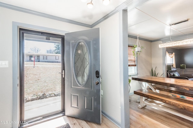 entrance foyer with light wood-type flooring, baseboards, visible vents, and crown molding