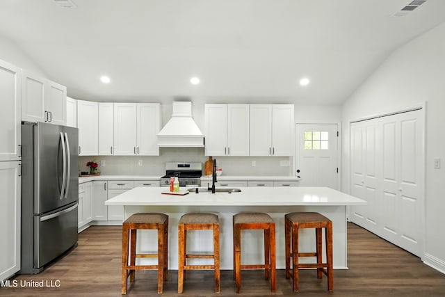 280 Bobby Ln, Picayune, MS 39466 - kitchen featuring stainless steel appliances, premium range hood, vaulted ceiling, a sink, and a kitchen breakfast bar