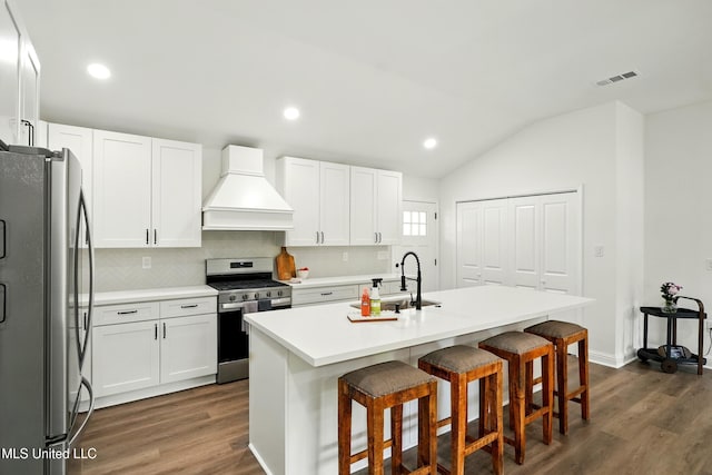 280 Bobby Ln, Picayune, MS 39466 - kitchen with stainless steel appliances, premium range hood, dark wood-type flooring, a kitchen bar, and vaulted ceiling