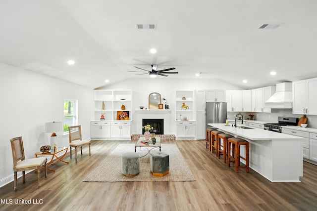 280 Bobby Ln, Picayune, MS 39466 - living area with lofted ceiling, wood finished floors, a ceiling fan, recessed lighting, and a fireplace with raised hearth
