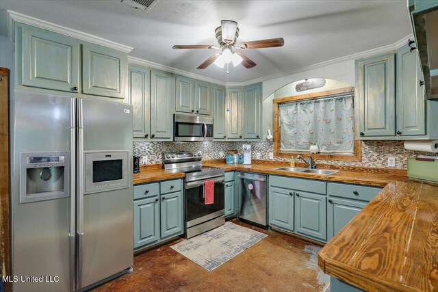 1563 Dry Creek Rd, Magee, MS 39111 - kitchen featuring stainless steel appliances, a sink, green cabinetry, and crown molding