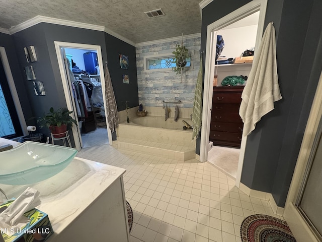 bathroom featuring tile patterned floors, a walk in closet, a garden tub, a shower, and vanity