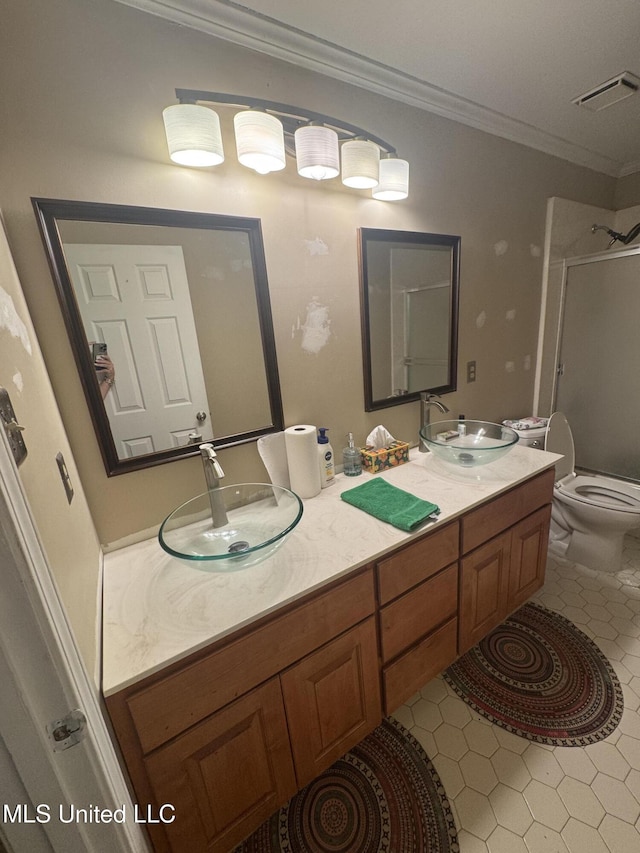 full bath with crown molding, tile patterned floors, a shower with shower door, toilet, and double vanity