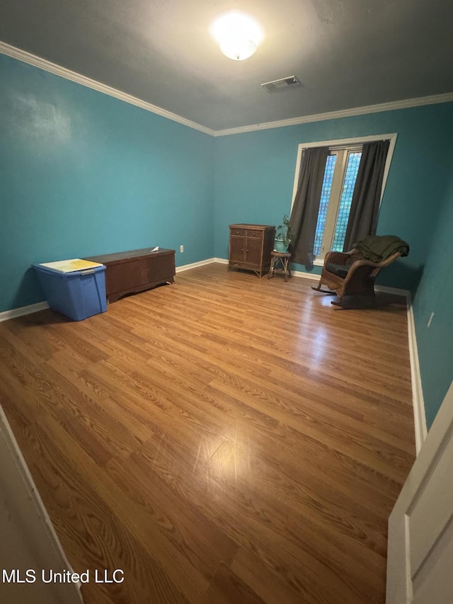 unfurnished bedroom featuring wood finished floors, ornamental molding, and baseboards