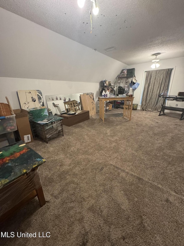 playroom with vaulted ceiling, carpet flooring, a ceiling fan, and a textured ceiling