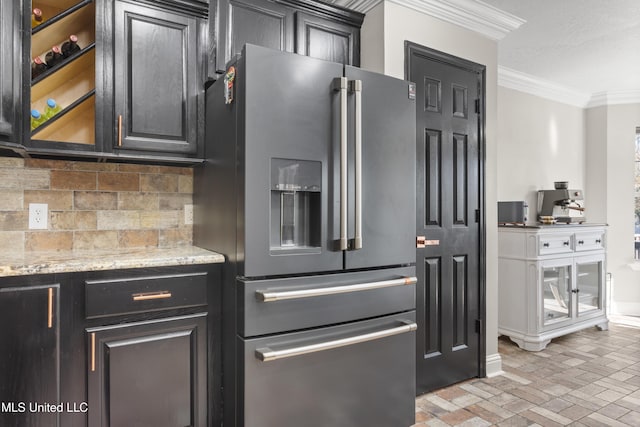 kitchen featuring light stone countertops, tasteful backsplash, high quality fridge, and ornamental molding