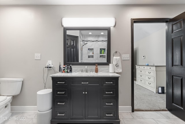 bathroom with vanity, toilet, and a tile shower