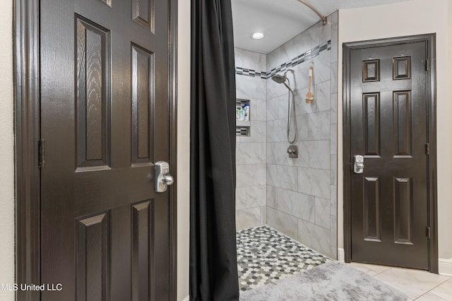 bathroom with tile patterned floors and a tile shower