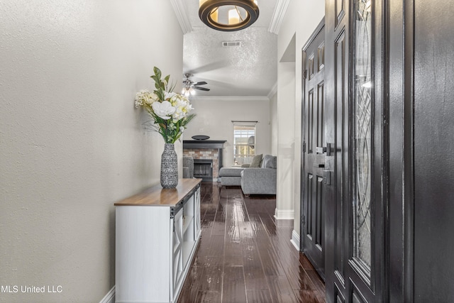 hall featuring dark hardwood / wood-style floors, crown molding, and a textured ceiling