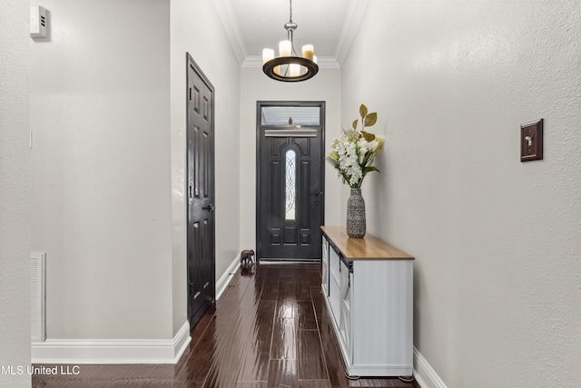 entryway featuring dark wood-type flooring, a notable chandelier, and ornamental molding