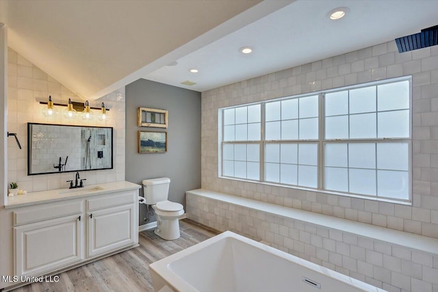 363 Lake Harbor Rd, Brandon, MS 39047 - bathroom with wood finished floors, a freestanding bath, toilet, vanity, and recessed lighting