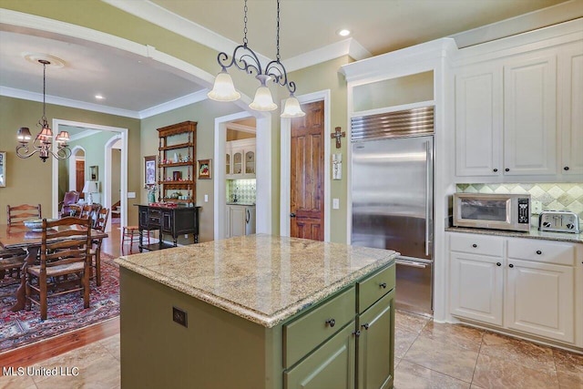 kitchen featuring white cabinetry, appliances with stainless steel finishes, a center island, and hanging light fixtures