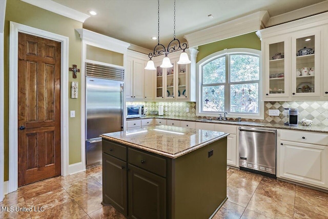 kitchen featuring a kitchen island, light stone countertops, stainless steel appliances, and backsplash