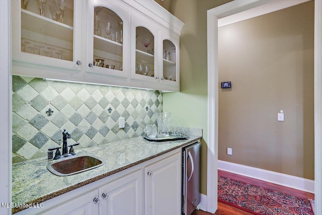 bar featuring white cabinetry, tasteful backsplash, sink, and hardwood / wood-style floors