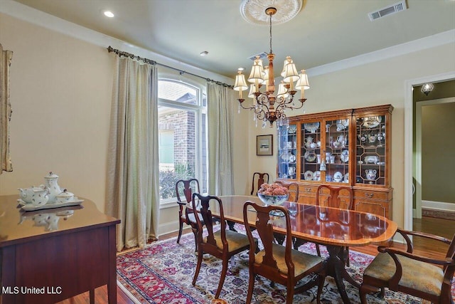 dining space with hardwood / wood-style flooring and an inviting chandelier