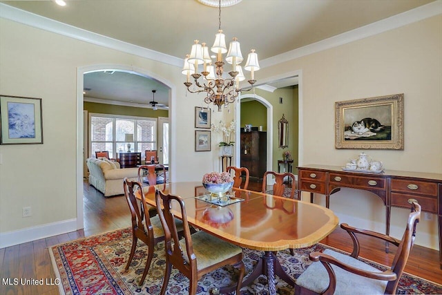 dining room with ornamental molding, ceiling fan with notable chandelier, and dark hardwood / wood-style flooring