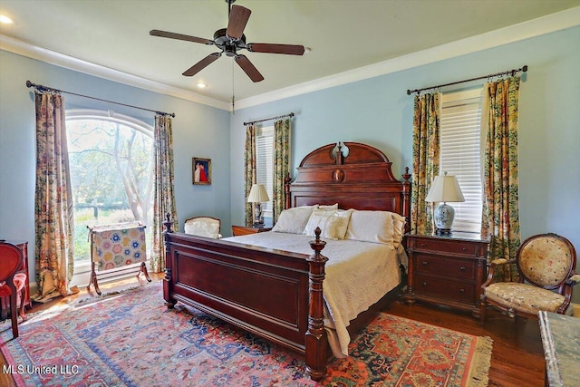 bedroom with dark wood-type flooring, crown molding, and ceiling fan