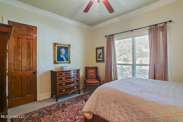 carpeted bedroom with ornamental molding and ceiling fan