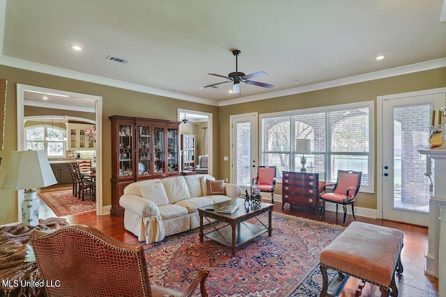 living room with ceiling fan, ornamental molding, and hardwood / wood-style floors