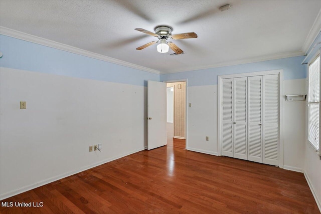 unfurnished bedroom featuring hardwood / wood-style floors, a textured ceiling, ceiling fan, and crown molding