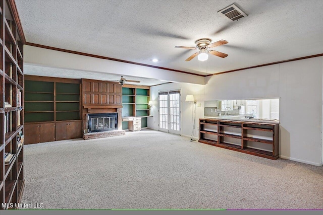 unfurnished living room with crown molding, carpet, and a textured ceiling