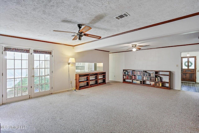 misc room featuring french doors, ornamental molding, a textured ceiling, ceiling fan, and carpet floors