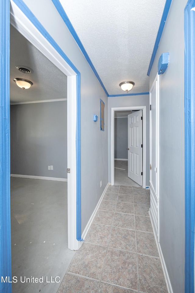 hall featuring a textured ceiling and crown molding