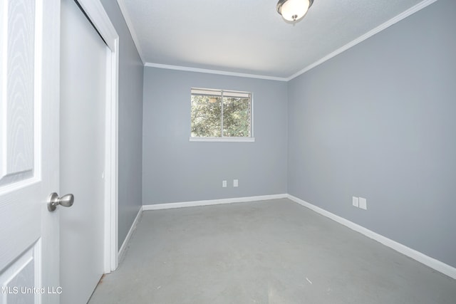 empty room with concrete flooring and crown molding