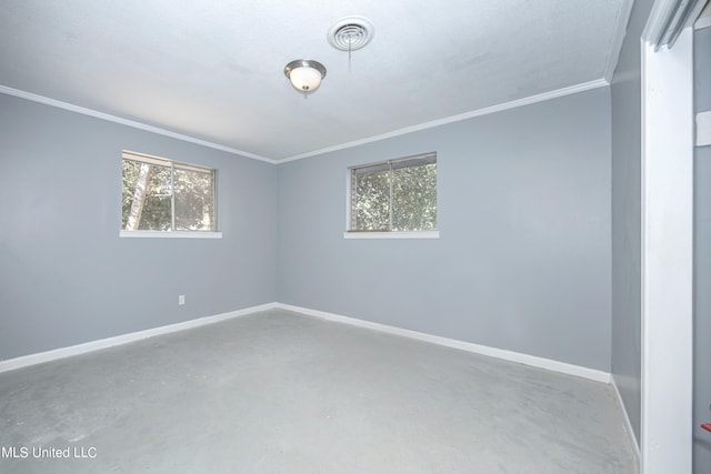 empty room with concrete flooring, a healthy amount of sunlight, and crown molding