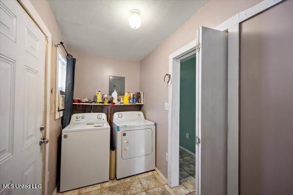 laundry room featuring electric panel and separate washer and dryer