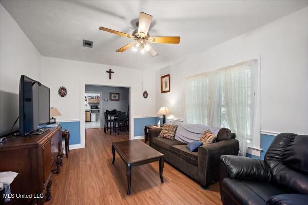 living room with wood-type flooring and ceiling fan