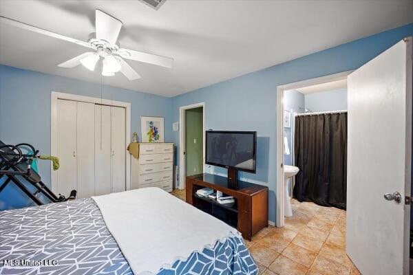 bedroom with light tile patterned floors, connected bathroom, and ceiling fan