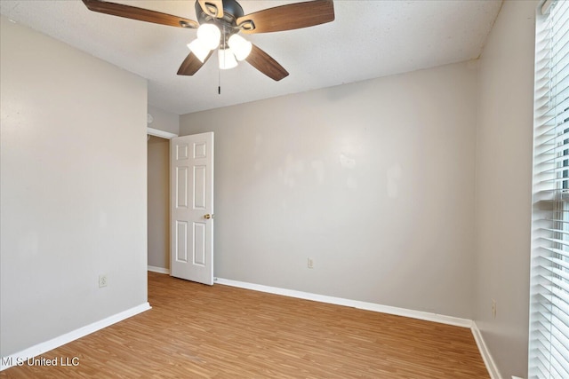 spare room with light wood finished floors, baseboards, and a ceiling fan