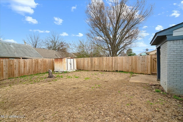 view of yard with a fenced backyard, an outdoor structure, and a shed